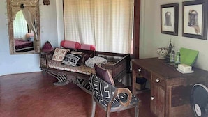 A traditional room with a wooden sofa, a small table, and a mirror. - The Lookout Pai (Pai)