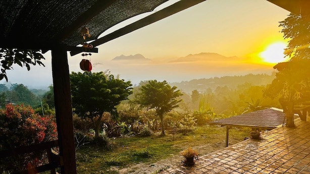 A patio area with a tiled floor, a wooden bench, and a hanging lantern. - The Lookout Pai (Pai)