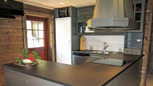 Una cucina moderna con isola centrale, elettrodomestici in acciaio inossidabile e una parete di fondo in legno.