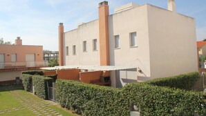 A modern building with a flat roof, rectangular windows, and two chimneys. - Nice apartment with private terrace (Creixell)