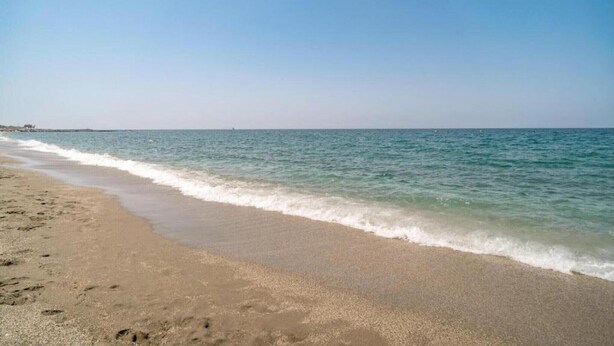 A beach with clear skies and calm waters.