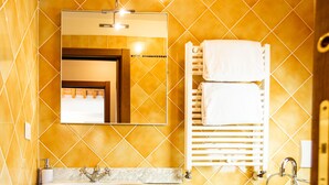 A bathroom with a large sink, a mirror, a towel rack, and a bidet. - Il Castellare, a delightful apartment in the heart of Sierna (Siena)