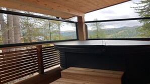 A wooden interior with a large window offering a view of a forested landscape. - Appealing chalet with finnish sauna (Turrach)