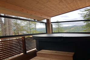 Un interior de madera con un ventanal grande que ofrece vistas a un paisaje boscoso.