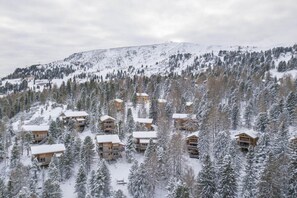 A snow-covered mountain with wooden cabins surrounded by trees. - Cozy chalet with sauna (Turrach)