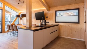 Eine moderne Küche mit Holzausstattung, einer Kochinsel und einem großen Fenster.