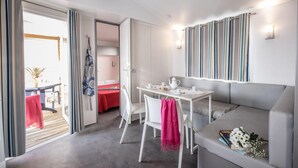 A modern hotel room with a dining area, a sofa, and a view of the outdoors. - Charming Getaway with Garden (Tarragona)