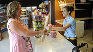 A person handing over a rolled-up item to a cashier in a store. - Bungalow in Malgrat near Golden Beaches (Barcelona)