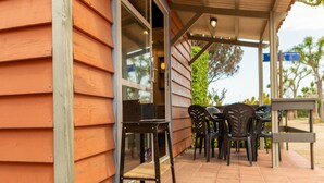 A covered patio with outdoor seating, a grill, and a view of the ocean. - Bungalow in Malgrat near Golden Beaches (Barcelona)
