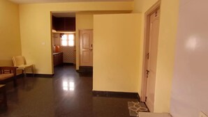 Een gang met een eetgedeelte, een keuken en een deur naar een andere kamer.