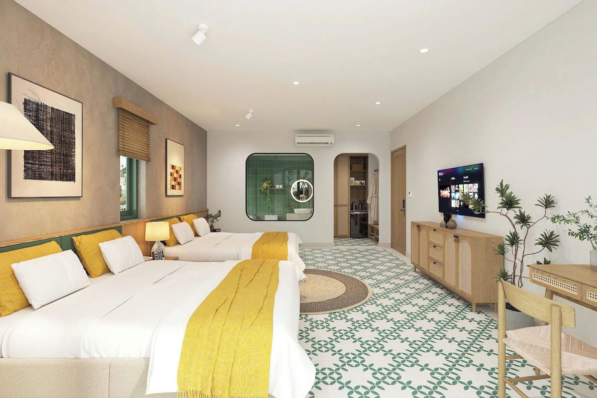 Ein Hotelzimmer mit zwei Betten, einem Fernseher, einem Holzschrank und einem grün gemusterten Boden.