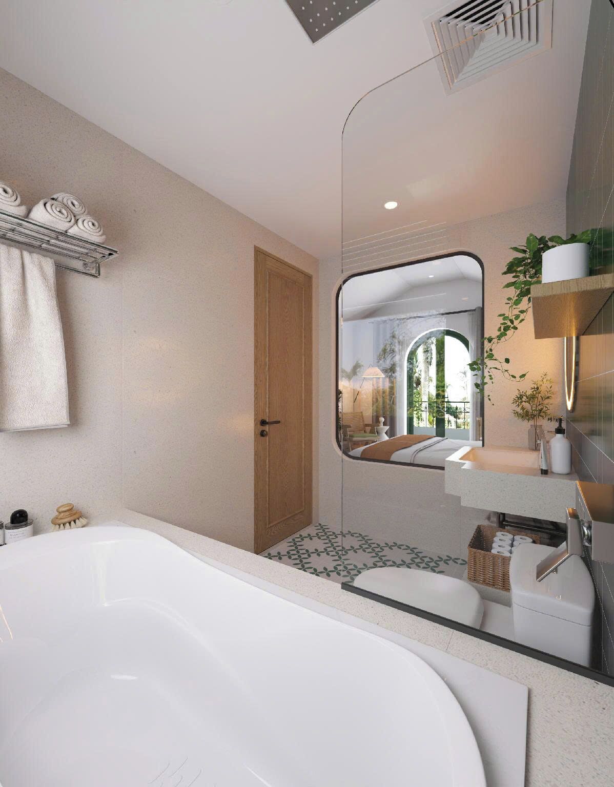 A modern bathroom with a large bathtub, a wooden door, a mirror reflecting a room with a view, and a shelf with toiletries.