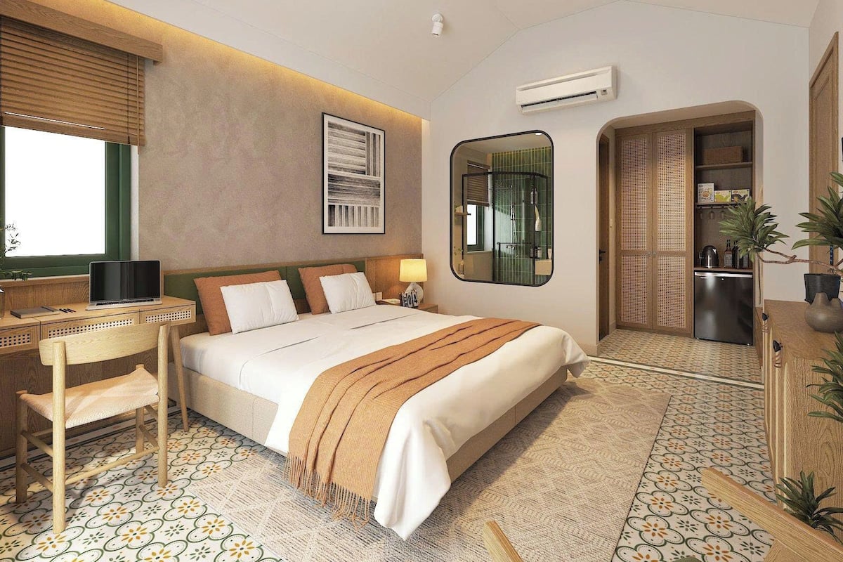 Ein modernes Hotelzimmer mit Bett, Schreibtisch und Kleiderschrank.