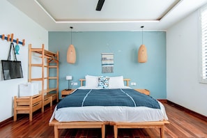 A neatly arranged bedroom with a bed, wooden furniture, and a wall-mounted rack.