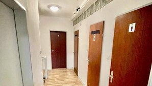 A hallway with wooden flooring, white walls, and doors with a red finish. - Enchanting hotel with WiFi in vibrant Wien (Wien)