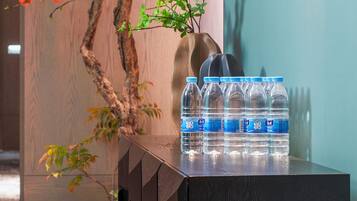 A wooden table with water bottles and a vase with a plant.