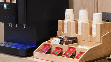 Un espace dédié au café, équipé d’une machine à café, de gobelets jetables et de capsules de café.