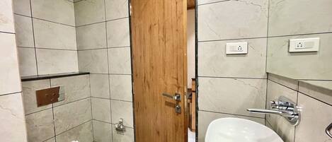 Baño con inodoro, lavabo y puerta de madera.