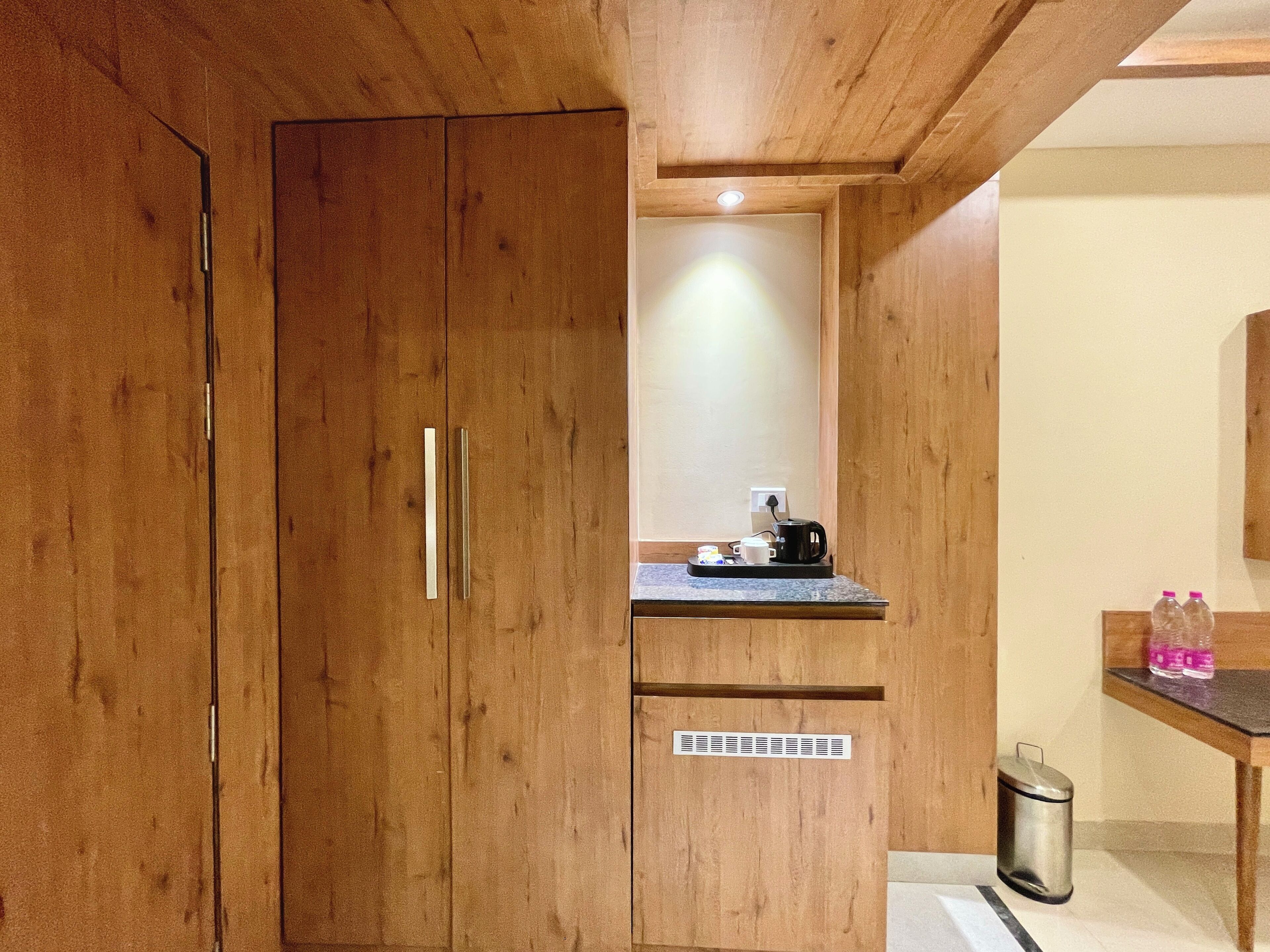 A wooden cabinet with a built-in microwave and a small countertop with a coffee maker.