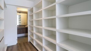 A walk-in closet with multiple shelves and a doorway leading to a bathroom. - w* | Fabulous 2BR w/ Balcony in Miraflores (Miraflores)
