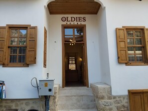 The entrance to Oldies Hotel with wooden shutters, a staircase leading inside, and a visible electrical box. - Oldies Hotel Bistro Restaurant (Antalya)