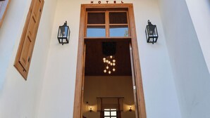 A hotel entrance with a sign reading "OLIDIES HOTEL," wooden shutters, and two wall-mounted lanterns. - Oldies Hotel Bistro Restaurant (Antalya)