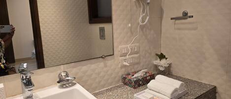 A bathroom with a sink, mirror, towel rack, and a tissue box.