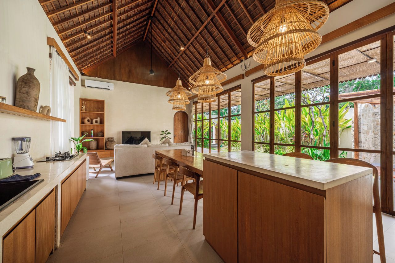 A spacious kitchen with a large island, wooden cabinets, and a dining area with a table and chairs.