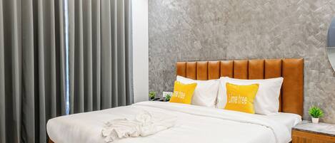 A modern bedroom with a large bed, grey curtains, a textured wall, and a ceiling fan.
