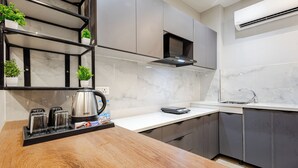 A modern kitchen with marble countertops, a built-in stove, and a stainless steel sink. - Street Studio by Lime Tree Hotels (Gurugram)