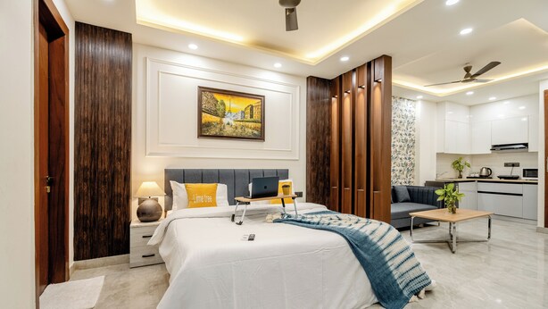 A modern bedroom with a bed, bedside tables, a desk, and a sofa. - Street Studio by Lime Tree Hotels (Gurugram)