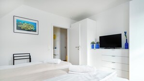Een slaapkamer met een bed, een televisie en een kledingkast.