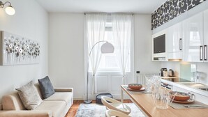 A modern kitchen with white cabinets, a dining table with chairs, and a large window with sheer curtains. - Easylife - Refined apartment in Duomo (Milano)