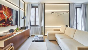 A modern living room with a sofa, a coffee table, a TV, and a fireplace.