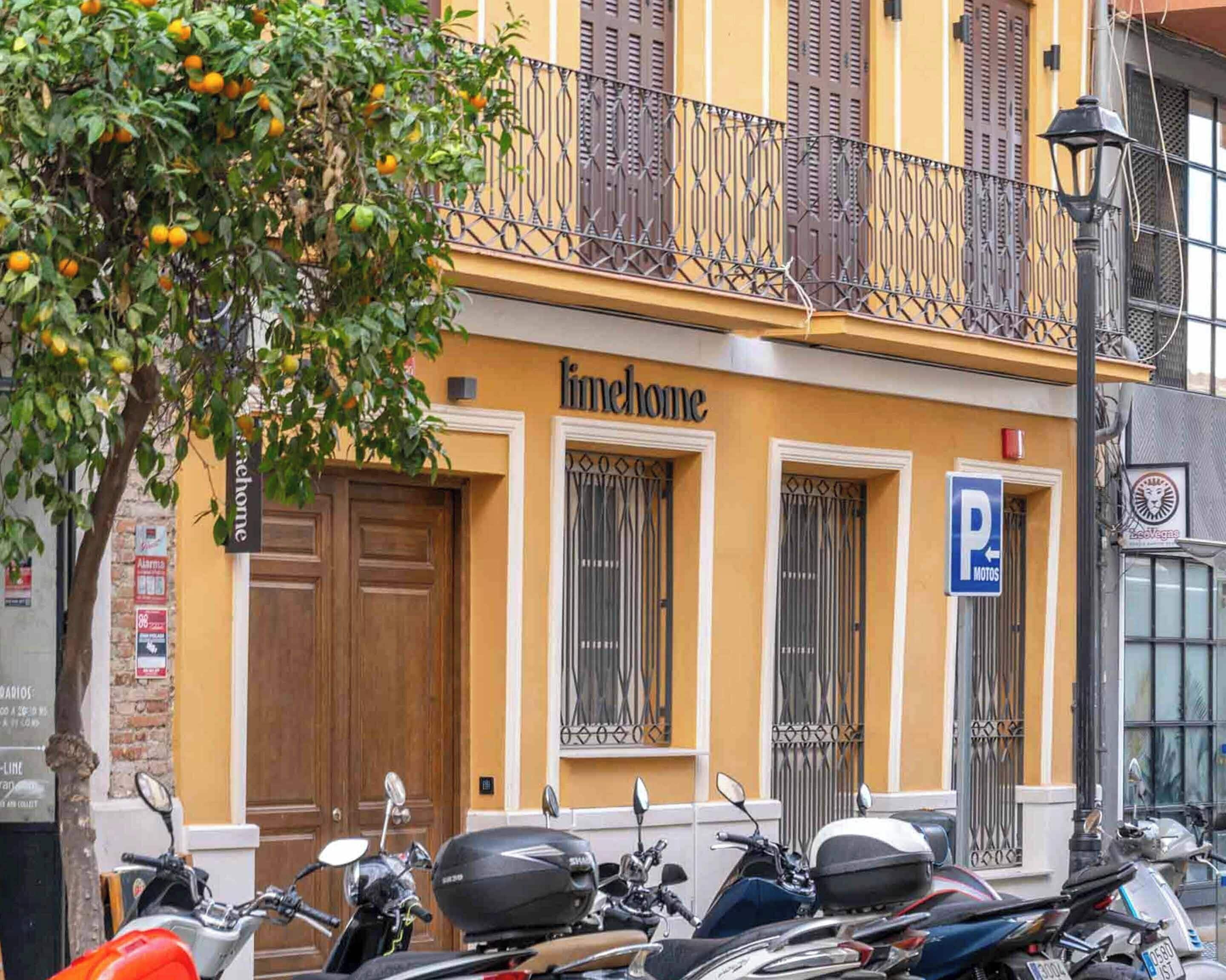 A building with a 'linehome' sign, a parking sign, and several parked scooters.