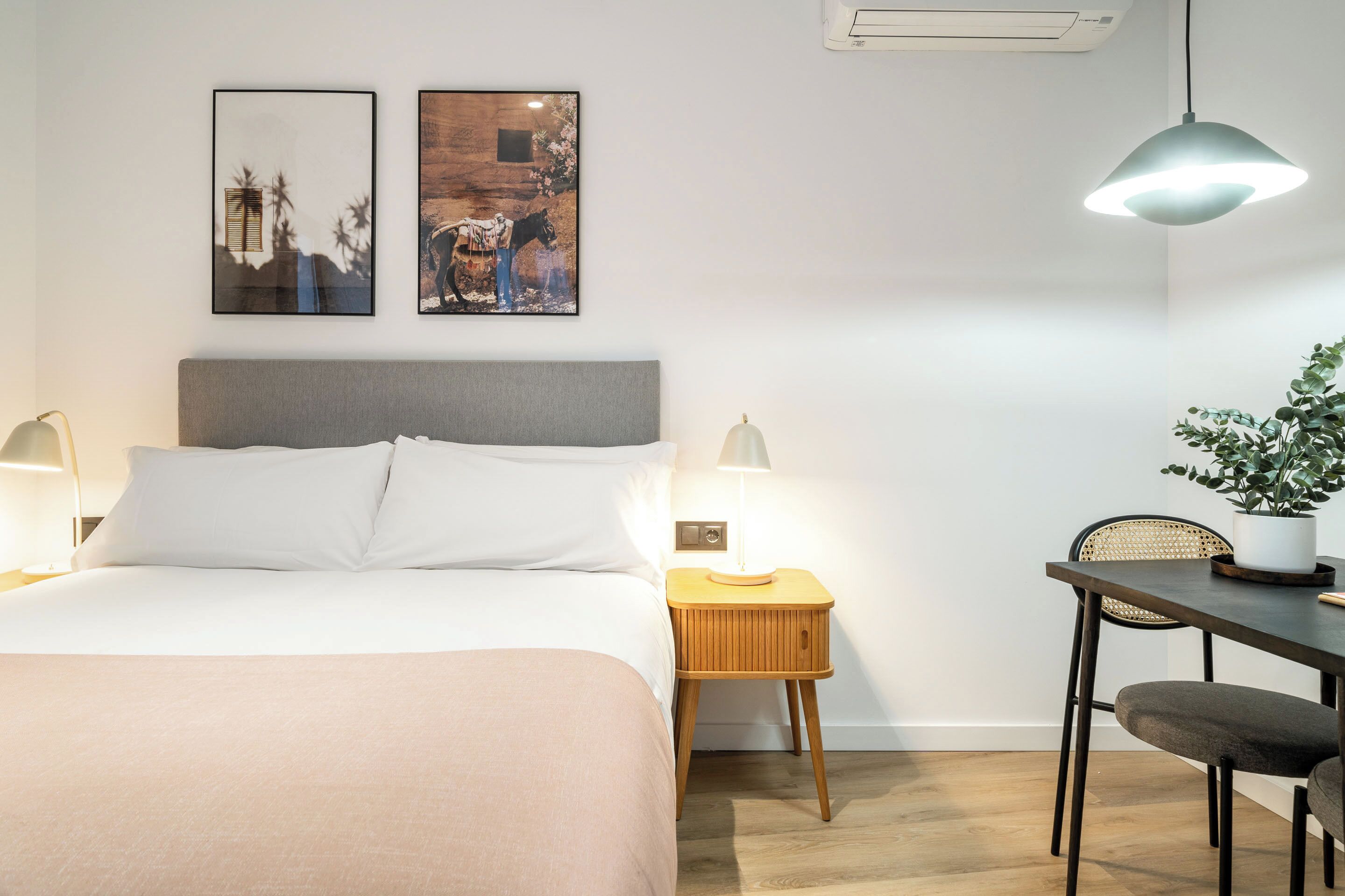 Une chambre à coucher bien rangée, avec un lit, des tables de chevet, un bureau et une chaise.