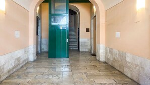 A corridor with a green elevator, stone flooring, and arched ceilings. - Casa La Palmetta by Wonderful Italy (Bari)
