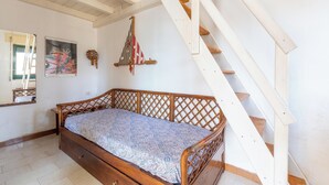 A bedroom with a wooden bed, a staircase, and a wall-mounted decorative item. - 4005 Villetta Stella by Barbarhouse (Manduria)