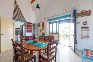 A dining area with a wooden table, chairs, and a view of the outside. - 4005 Villetta Stella by Barbarhouse (Manduria)