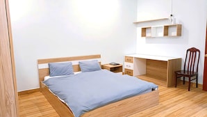 A bedroom with a wooden bed, a desk, and a chair. - OYO 1248 Quyen House (Cam Ly - Da Lat)