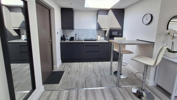A modern kitchen with grey cabinets, a black countertop, and a skylight above the sink. - Lodge - Sleeps 2 - Pet Friendly - Parking - Patio (Sidcup)