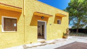 A yellow building with a door and windows, a small balcony, and a potted plant. - 4087 Cascina Mimì by Barbarhouse (Nardò)