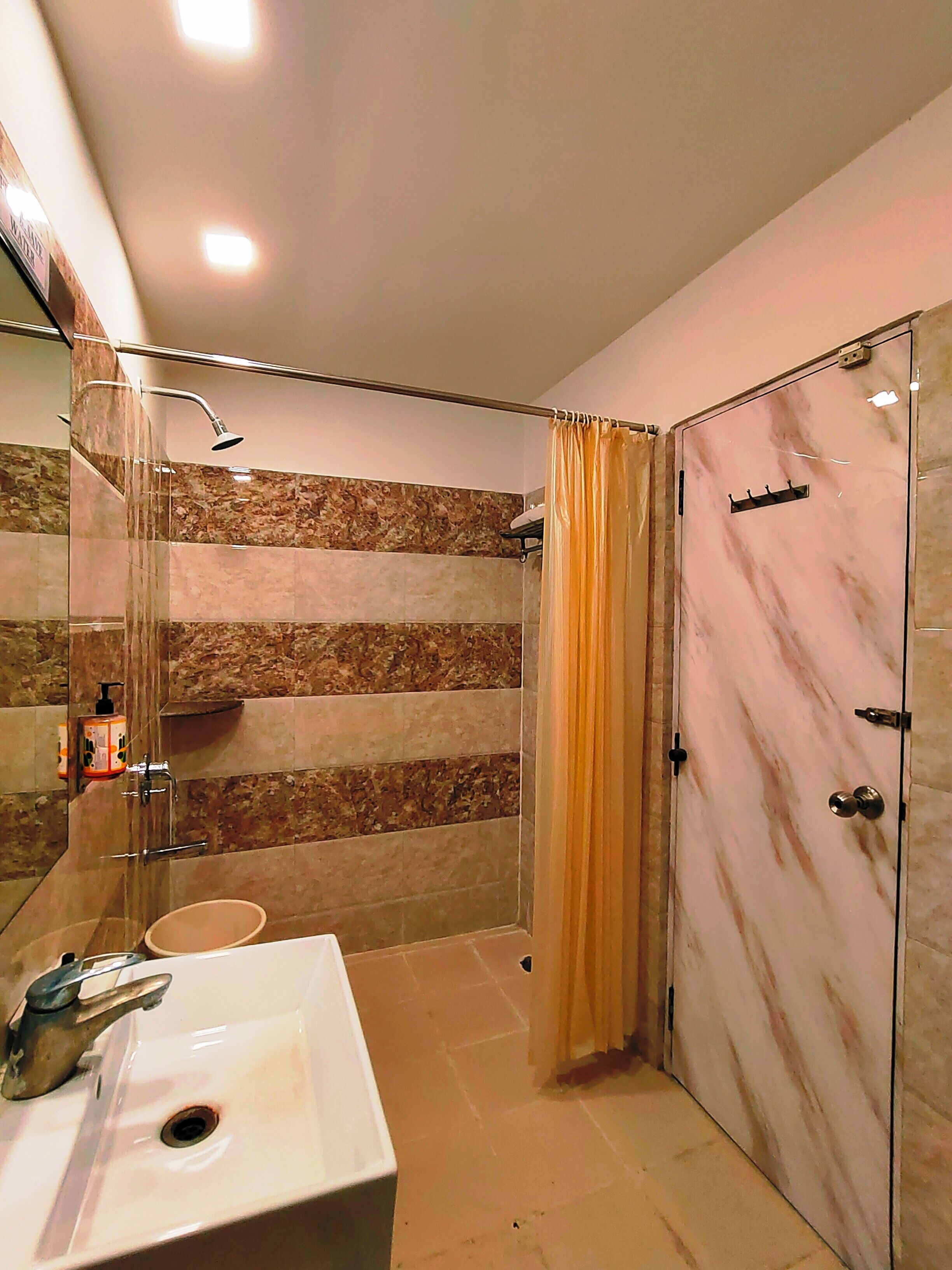 Une salle de bain moderne dotée d’une douche à parois de verre, d’un meuble-lavabo en marbre et d’une douche à l’italienne.