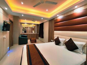 Une chambre d’hôtel moderne dotée d’un grand lit, d’un coin salon et d’une télévision.