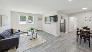 Een modern appartement met een woonkamer, keuken en eethoek.