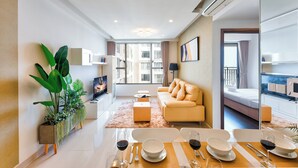 A modern living room with a sofa, dining table, and potted plants. - S Lux Apartment (Ho Chi Minh City)