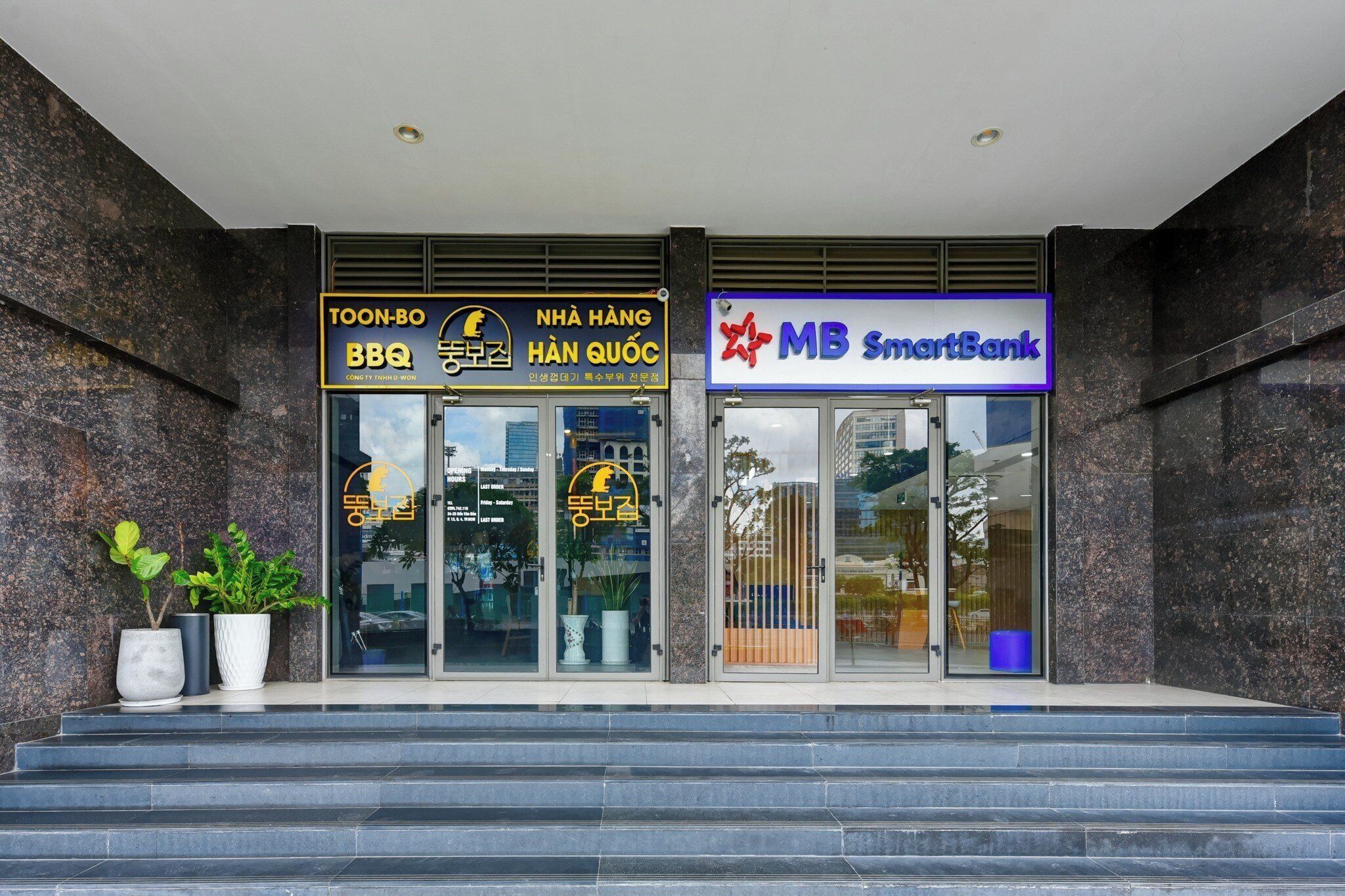 Entrada de un edificio con un restaurante de barbacoa y un SmartBank.