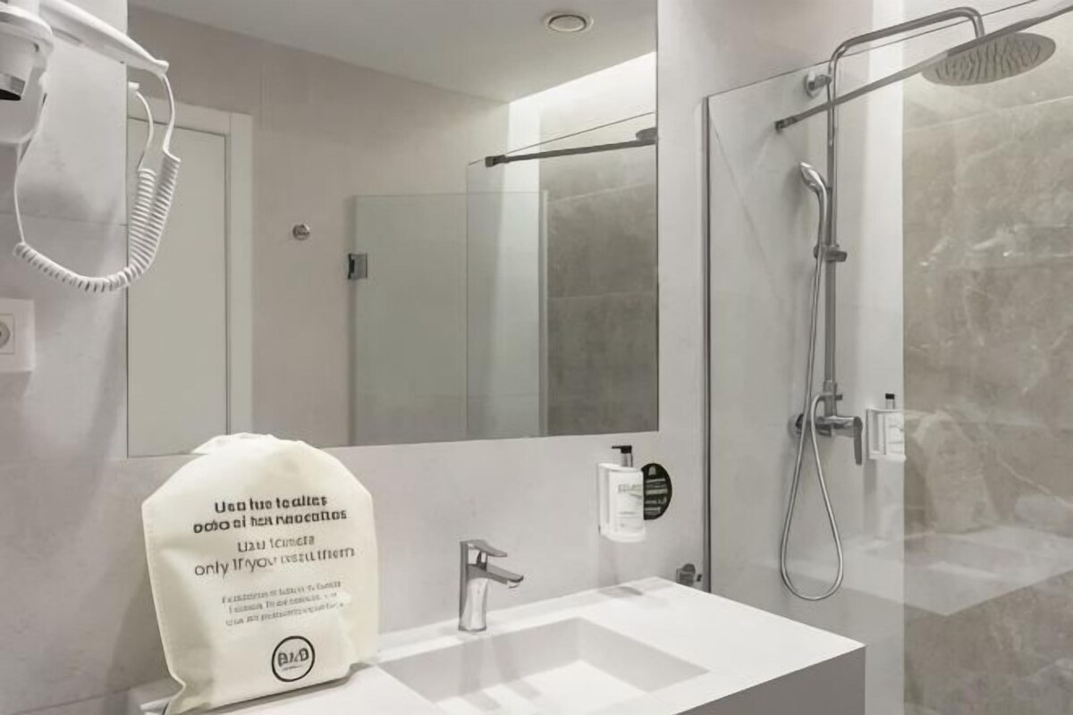 Un bagno moderno con lavandino, specchio e doccia.