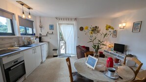 Une cuisine moderne avec un coin repas, comprenant une table avec des chaises, un téléviseur et une machine à café.
