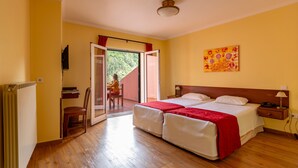 A double bed with a red blanket, a wooden nightstand, a wall-mounted TV, and a sliding glass door leading to an outdoor area. - Valley View Hotel Encumeada (Ribeira Brava)